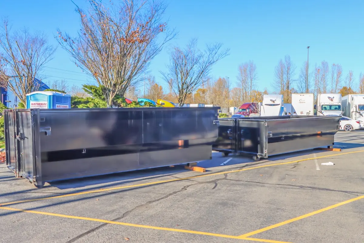Professional dumpster rental service with roll-off container on residential driveway in Compton